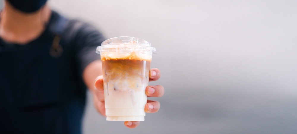 man reaching out a coffee to a customer