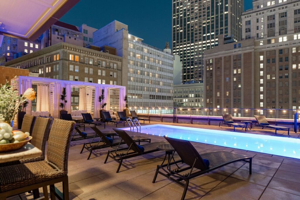 photo of the rooftop pool at NOPSI, with pool furniture and purple lights 