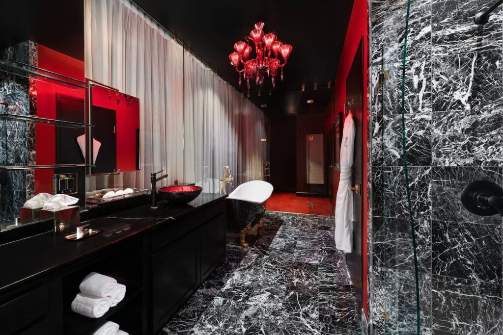 photo of a black marble and red painted bathroom at the saint hotel, one of the hotels in New Orleans 