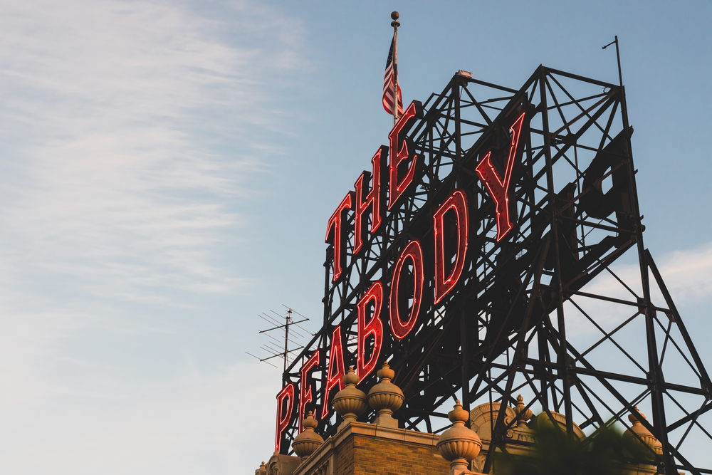 A view of the red neon sign that says 'The Peabody' on top of the Peabody Hotel Memphis. 