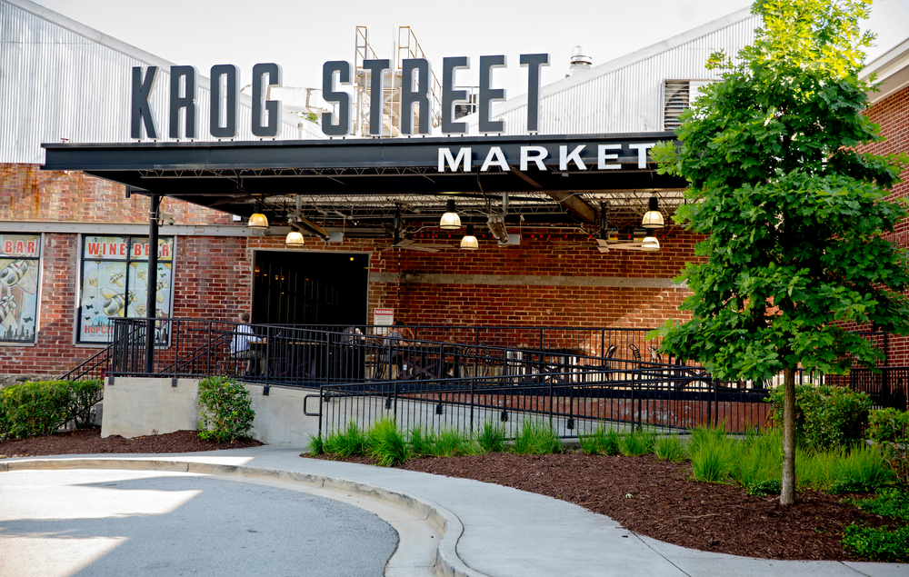 photo of an entrance to krog street market, with outdoor seating during the afternoon