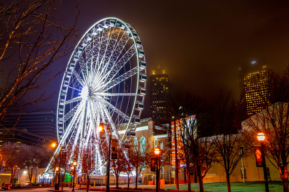 photo of sky view Ferris wheel, one of the best things to do in Atlanta at night, illuminated in white lights at night 