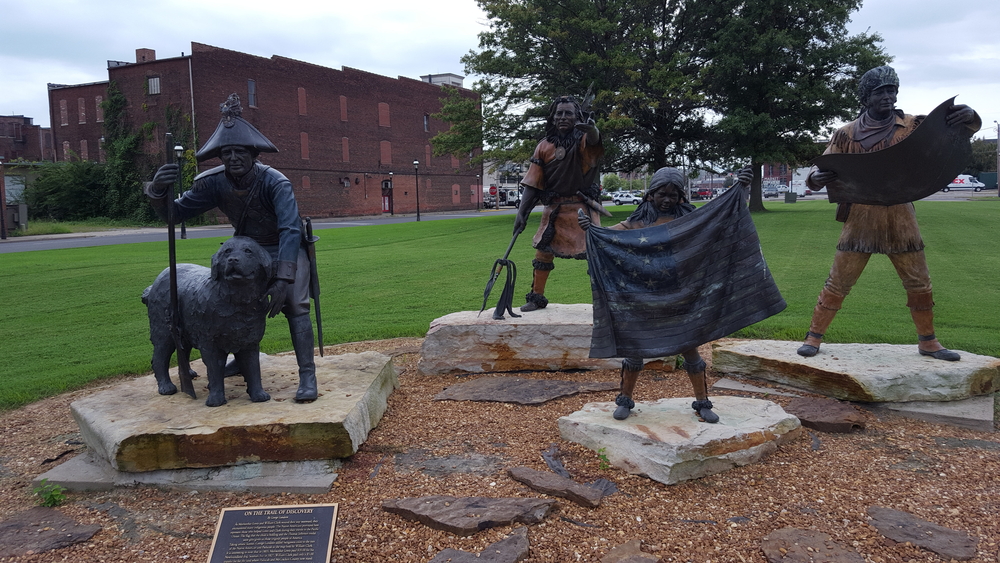 statues in front of a brick museum