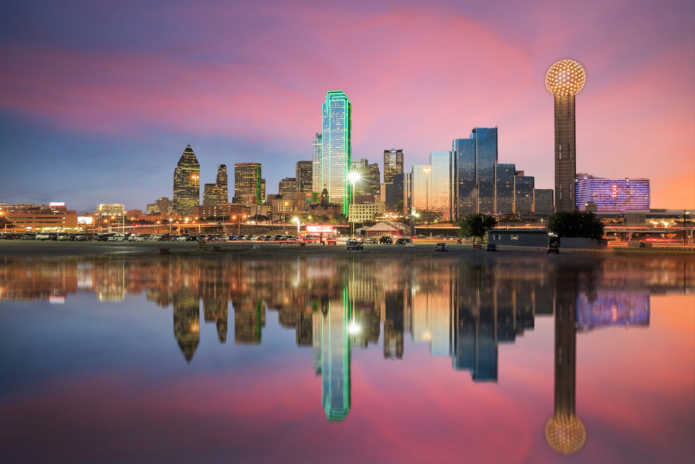 Dallas, Texas cityscape with blue sky at sunset, Texas. It shows the skyline across the lake
