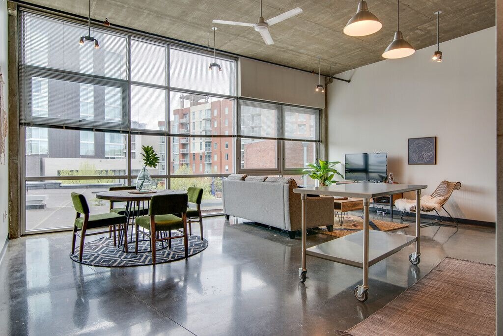 Lofts may be a great option for rentals and where to stay in Nashville. This loft features a wall made of all windows and has a spacious area for both the kitchen and the living room. 