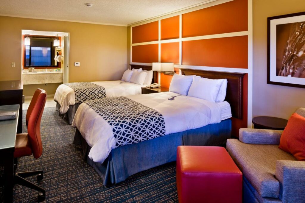 The Inn at Opryland is a classic place of where to stay in Nashville: this room features two beds, bright orange walls and a nice private bathroom. 