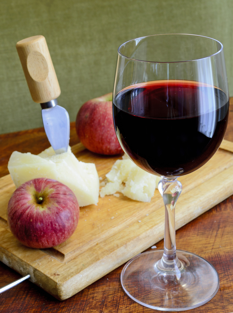 glass of wine, and cheese with a knife in it and an apple. ellijay river vineyard one of the best wineries in georgia