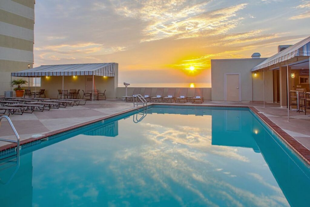 The sun rising over the ocean and roof top pool at one the beach oceanfront hotels in Virginia Beach. 
