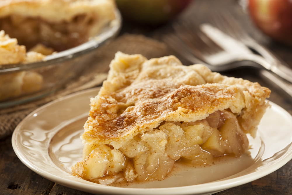 A slice of apple pie on a white plate.