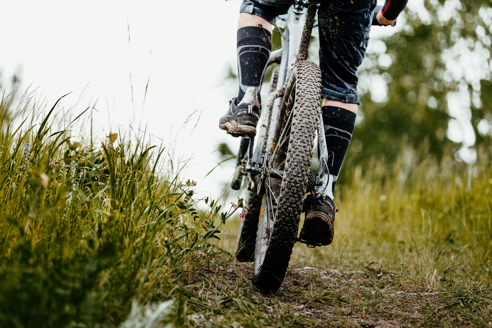 Low angle photo of a mountain bike tire from behind covered in mud in Boone, NC.