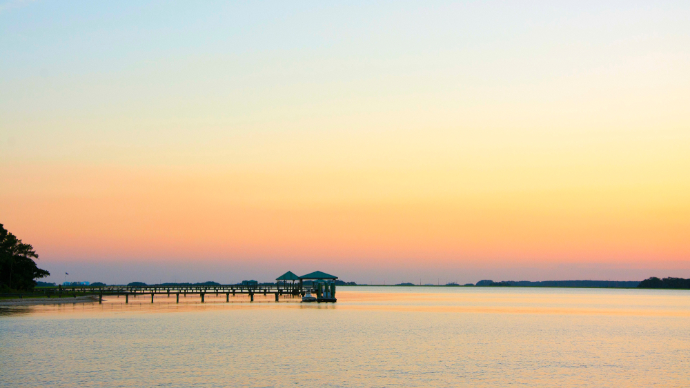 Sunrise over the water on a pier at one of the prettiest beaches in South Carolina 
