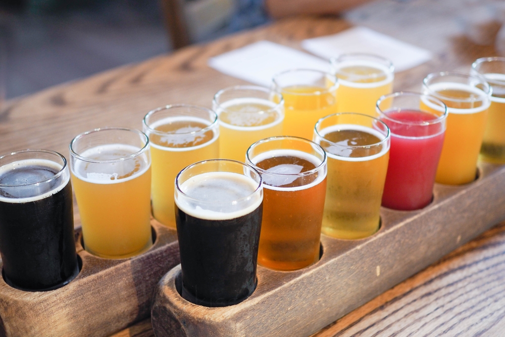 two flights of beers on a table, beers of different colors with bubbles on top