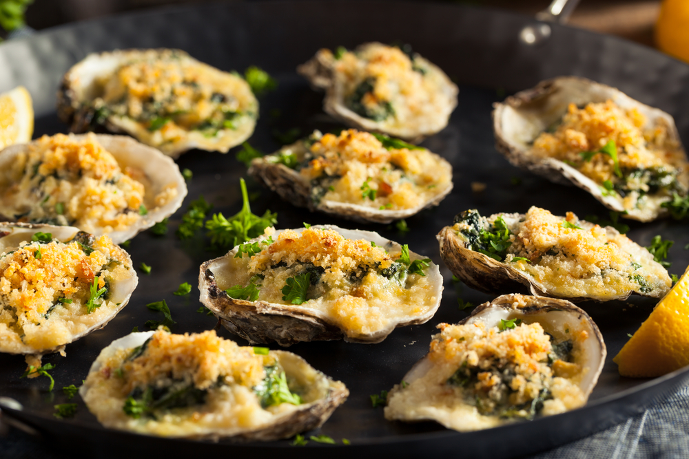 Oysters Rockefeller with Cheese and Spinach they are on a black tray 