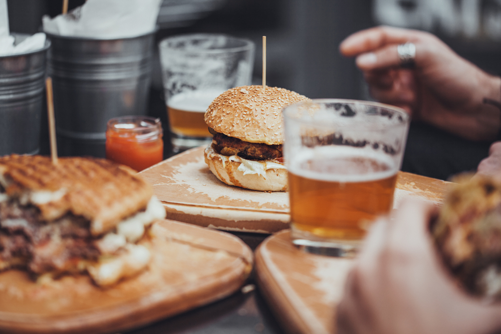 Delicious Pub Food. Burgers And Glasses Of Beer On Wooden Plates in an article about best restaurants in Fayetteville
