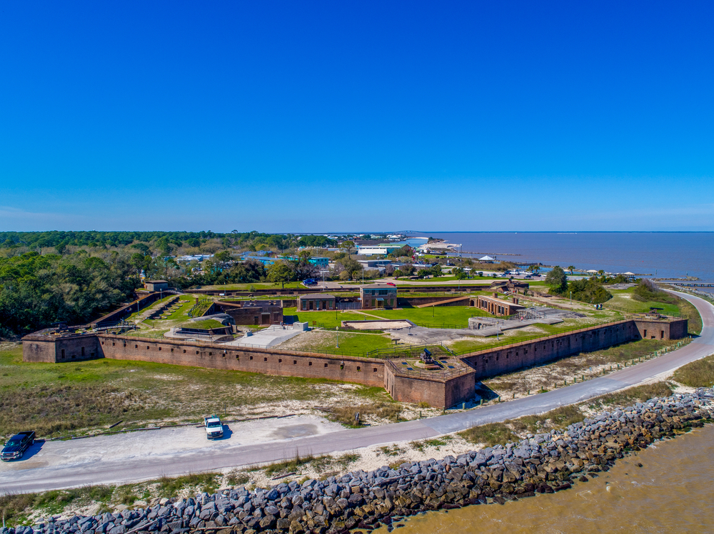 aerial photo of a fort on the waters edge in dauphin island, one of the best towns in alabama