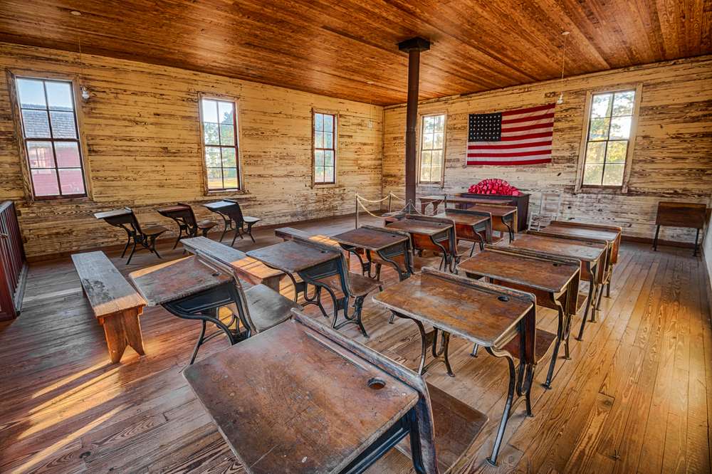 photo of an old one room school house with desks in rows
