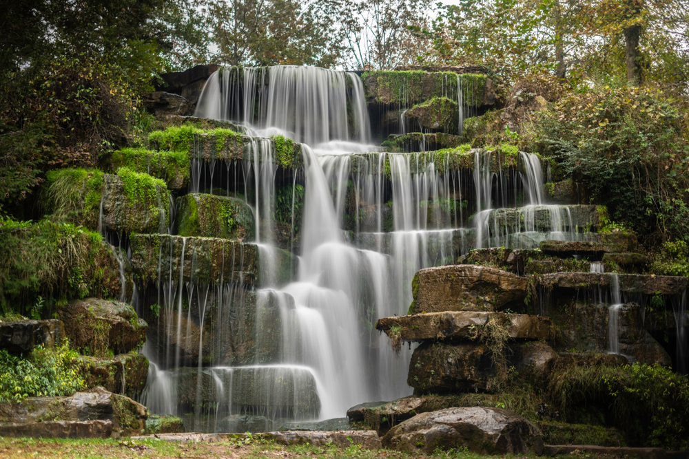 waterfall in the woods with green all around it