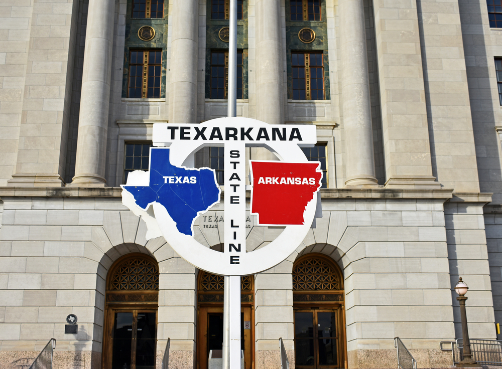 Photo of the sign in Texarkana designated the state line between Texas and Arkansas that runs between the town. This is one of the best towns to visit in Arkansas.