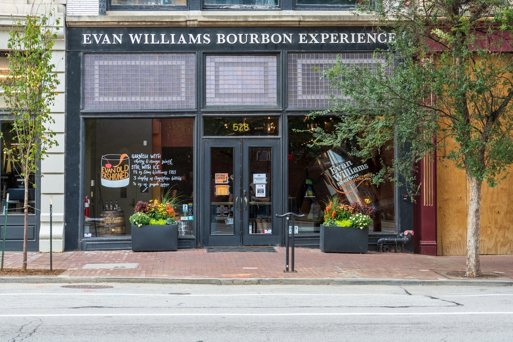 evan williams bourbon experience sign and building on street with trees out front, one of the best distilleries in louisville