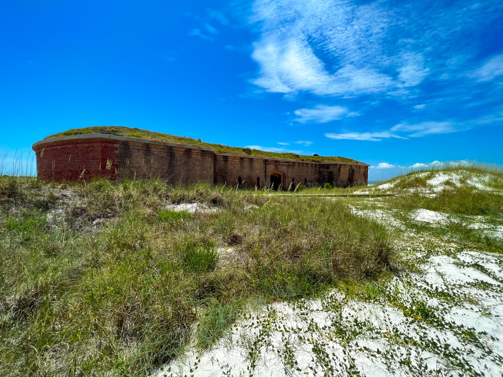 Sandy dunes and vegetation surrounds a fort on Ship Island, one of the best places to visit near Biloxi.