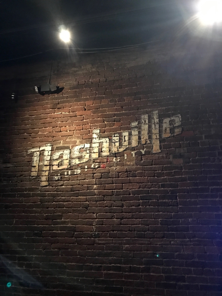 Brick wall with the text Nashville Music City mural. 