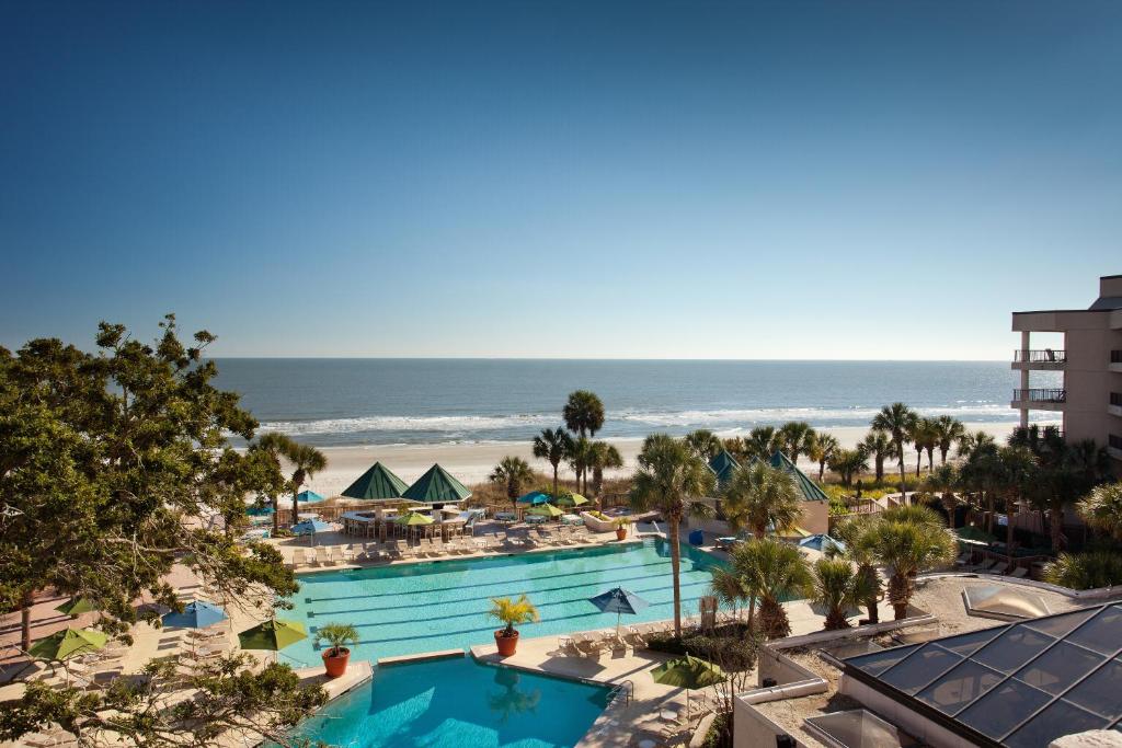 The pool area with trees right on the ocean 