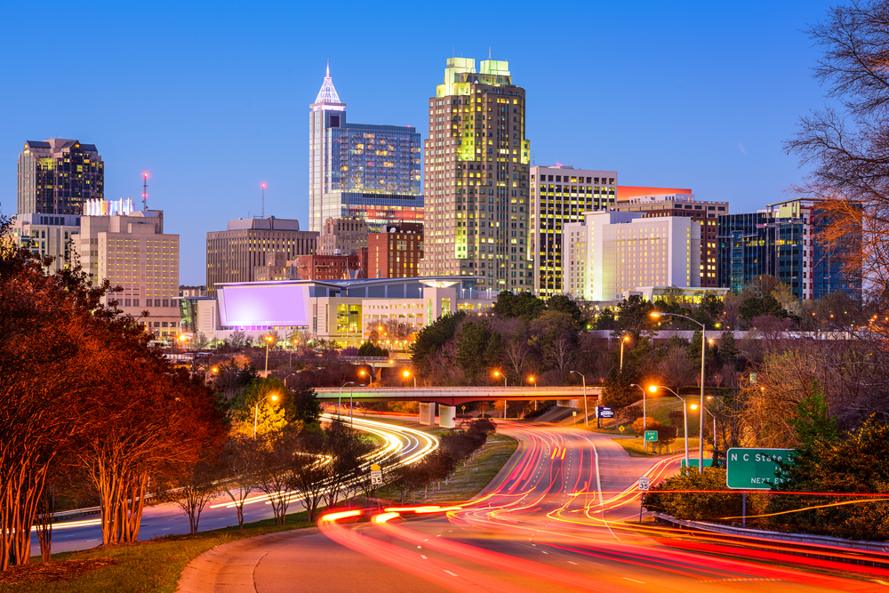 The view of downtown Raleigh at night time with all the lights on. 