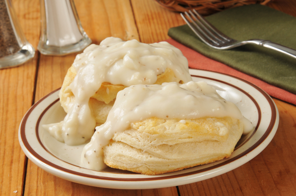 two biscuits with gravy on them on a plate on a table