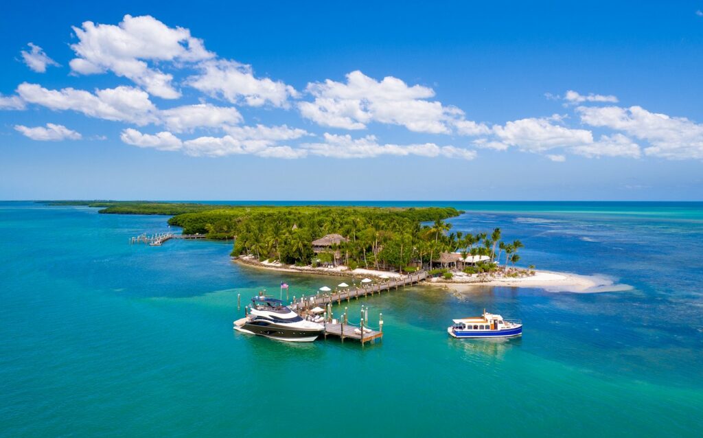 A wide shot of the Little Palm Island Resort as it sits on an Island in the Florida keys, the blue water making it one of the most recognizable and best resorts in the South.