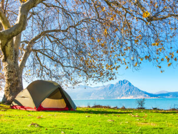 photo of a tent with a lake and mountain range in the back