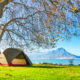 photo of a tent with a lake and mountain range in the back