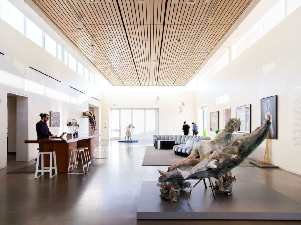 modern lobby that is decorated like a museum, man standing at front desk on the left