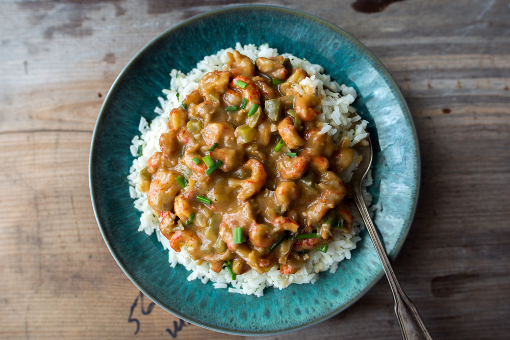 crawfish étouffée in a round plate with a spoon in the rice