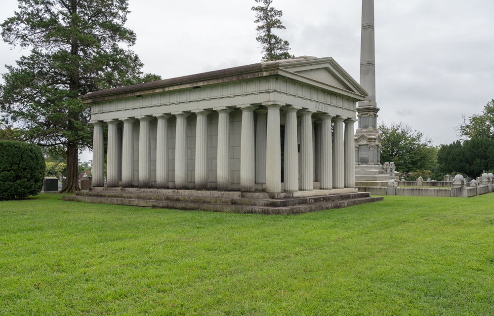 A super big grave in a cemetery with bright green grass. 