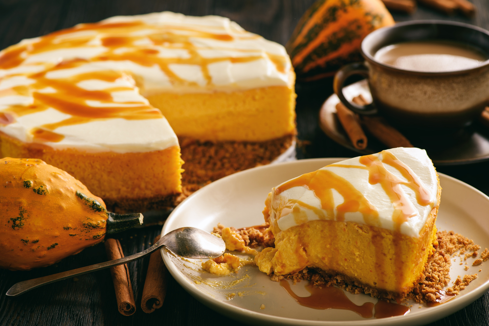  as seen in this photo: this pumpkin cheesecake is falling off a spoon and is accompanied with a cup of coffee.