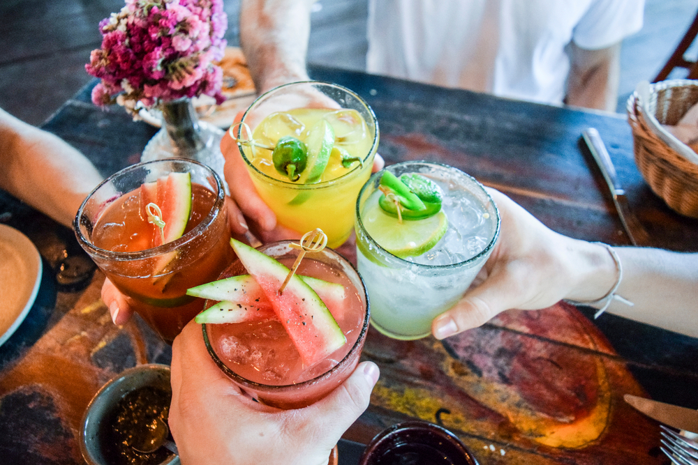  In this photo, a group of friends clinks their glasses together at a bar! 