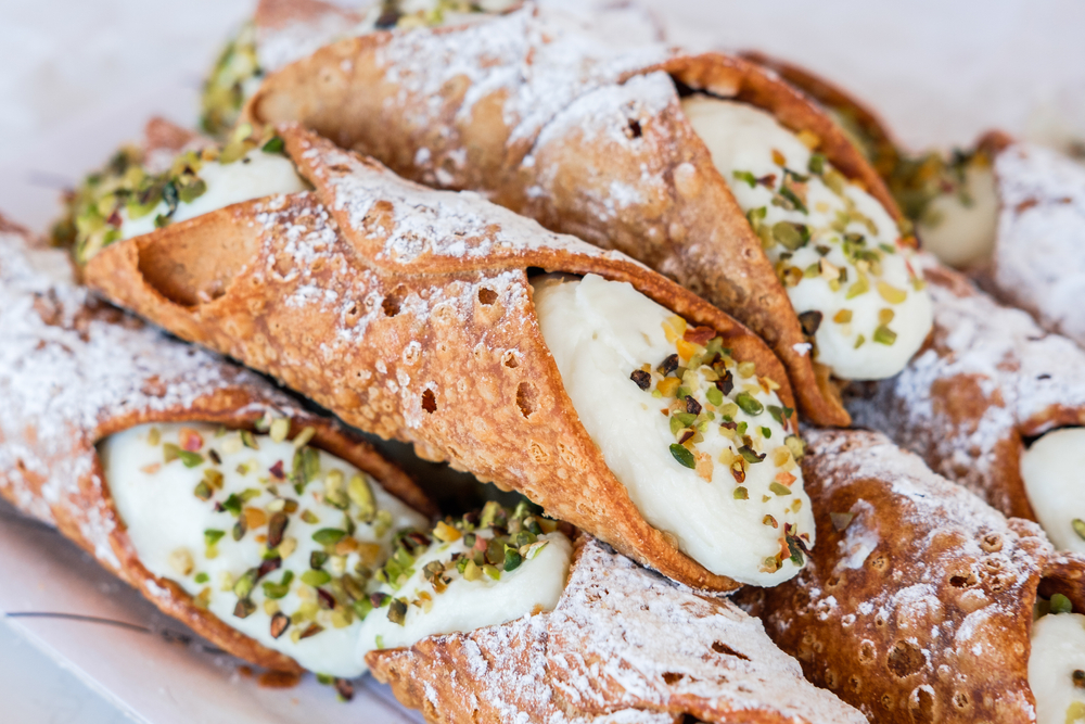 a pile of canoli on a plate with powdered sugar on top of them, piastra restaurant, one of the best restaurants in marietta 