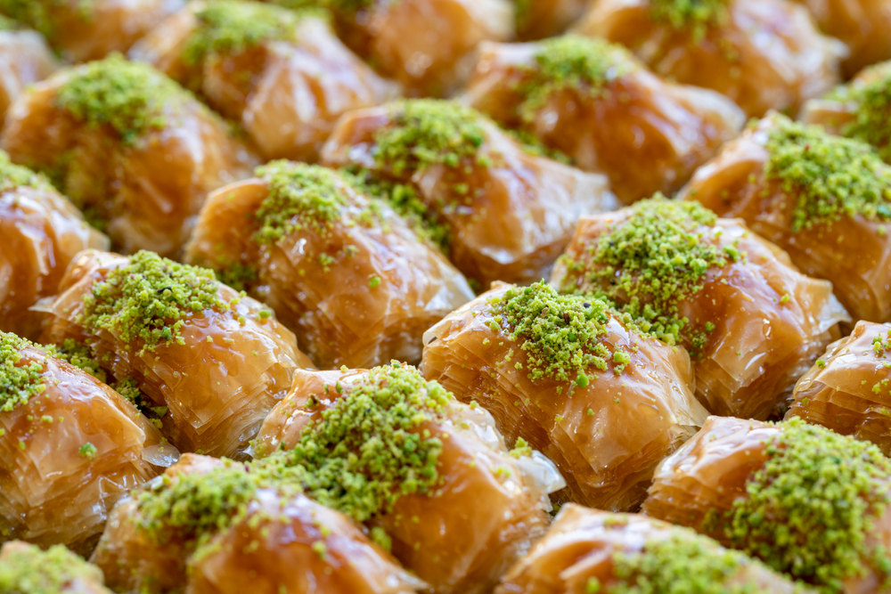 rows of rectangle servings of baklava with nut powder on top. 