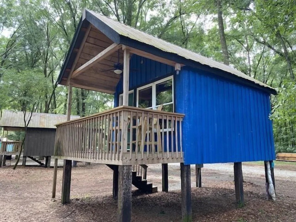 exterior view of the raised on stilts little blue cabin 