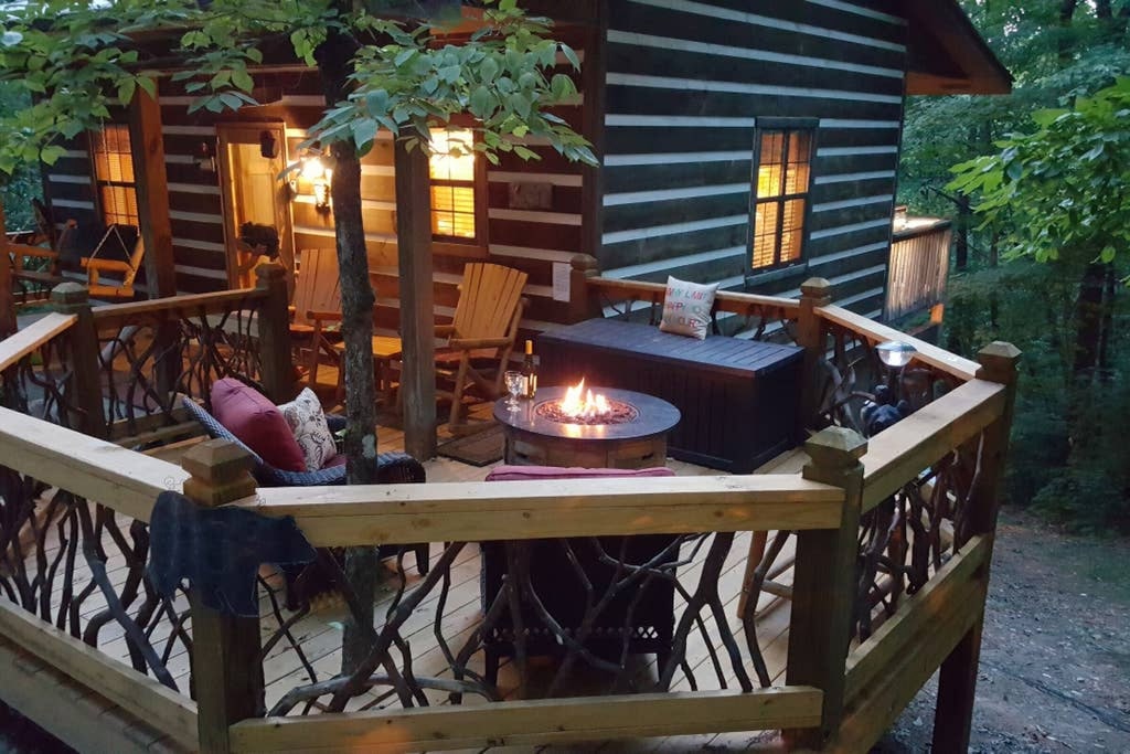 View of the cozy outdoor fireplace and awesome branch balcony railings of the Sweet Retreat 