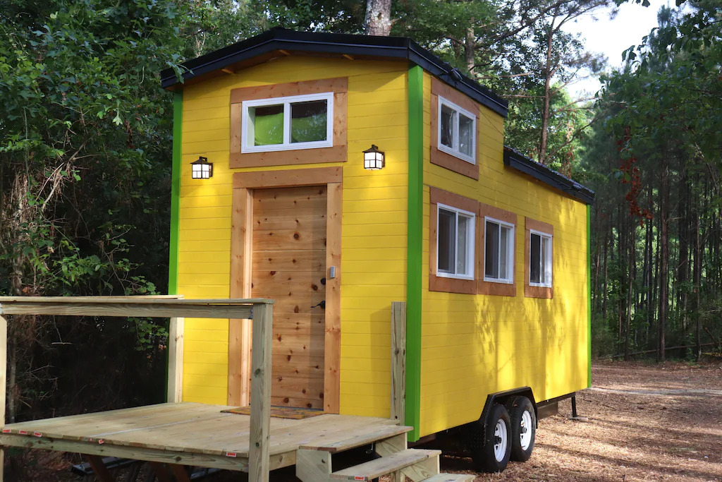 cute yellow tiny house in the georgia woodland 