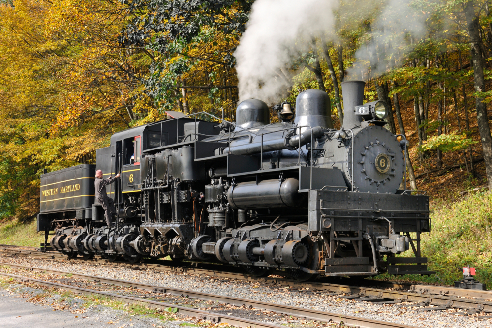 an old steam engine on railroad tracks in the woods in west virginia