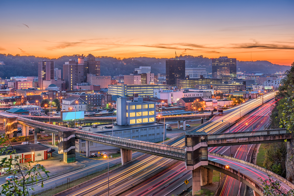 city scape at sunset, lights in buildings lit up and lights from cars on the roads