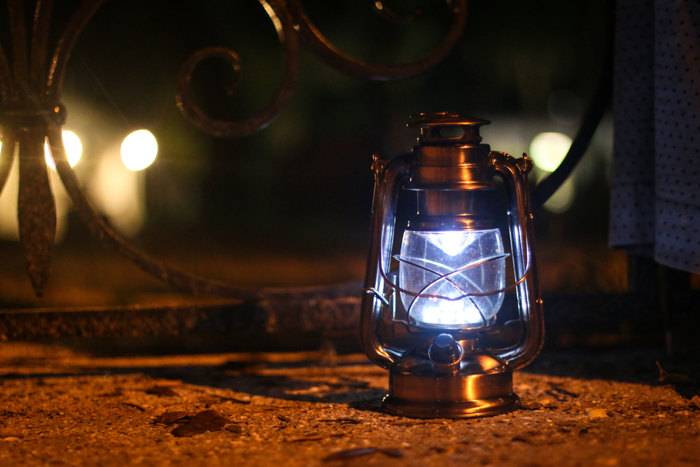 A lantern at night on one of the ghost tours sitting on a the ground 