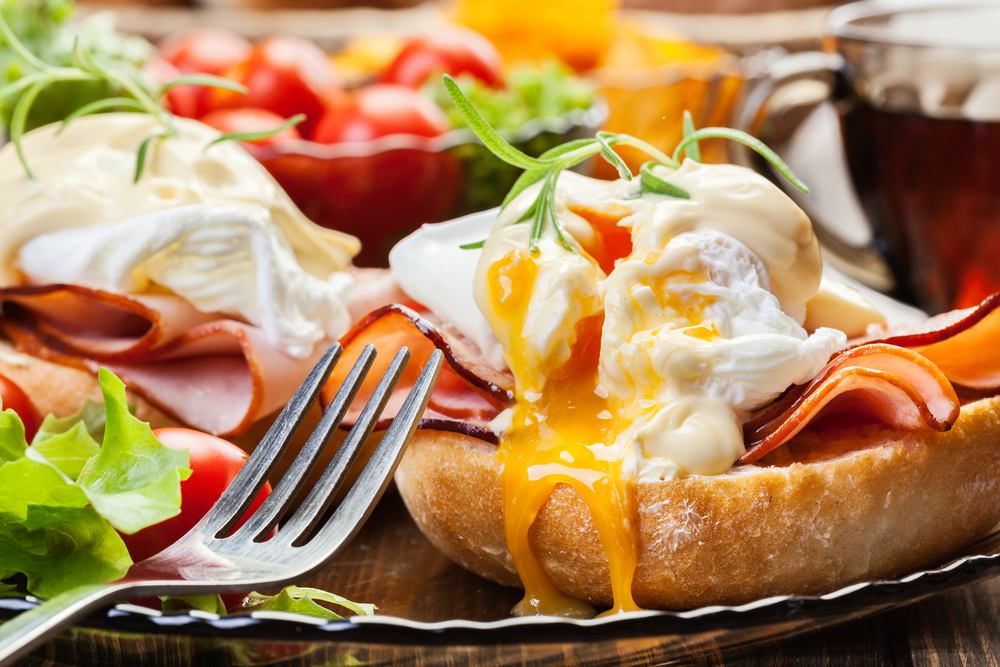 A yummy breakfast meal with eggs meat and salad. 