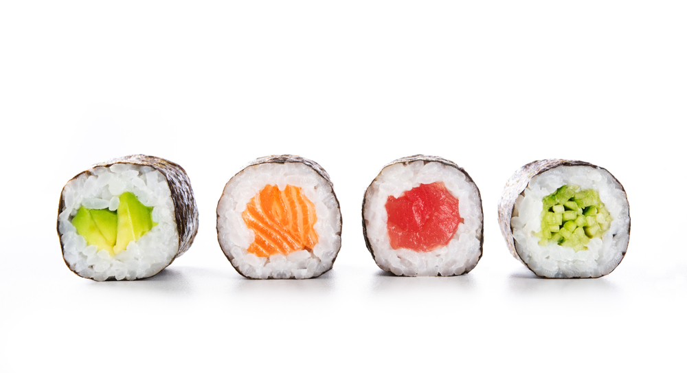 Four Fun sushi rolls with big pieces of meat and veggies inside. 