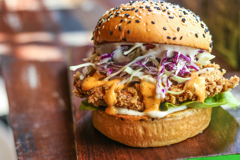 a delicious fried chicken sandwich topped with cheese and coleslaw