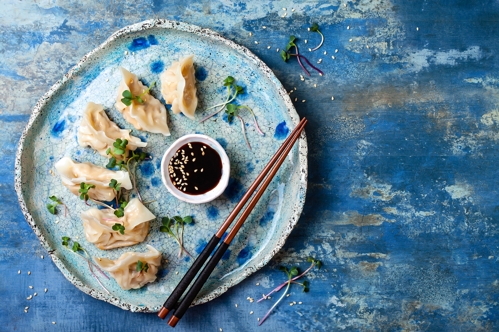 blue table with a blue ceramic dish and these amazing dumplings, delicious food made to be devoured!