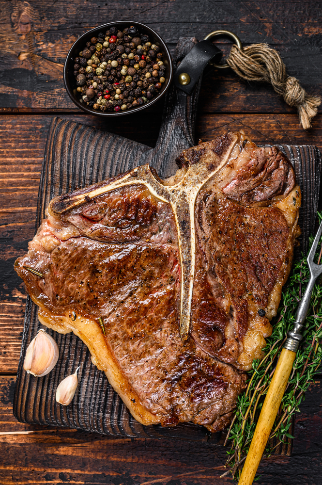 a gorgeous and freshly cooked t bone steak paired with some garlic, unground seasoning and rosemary sprigs! Don't miss out on some fantastically prepared proteins at the best restaurants in Salisbury!