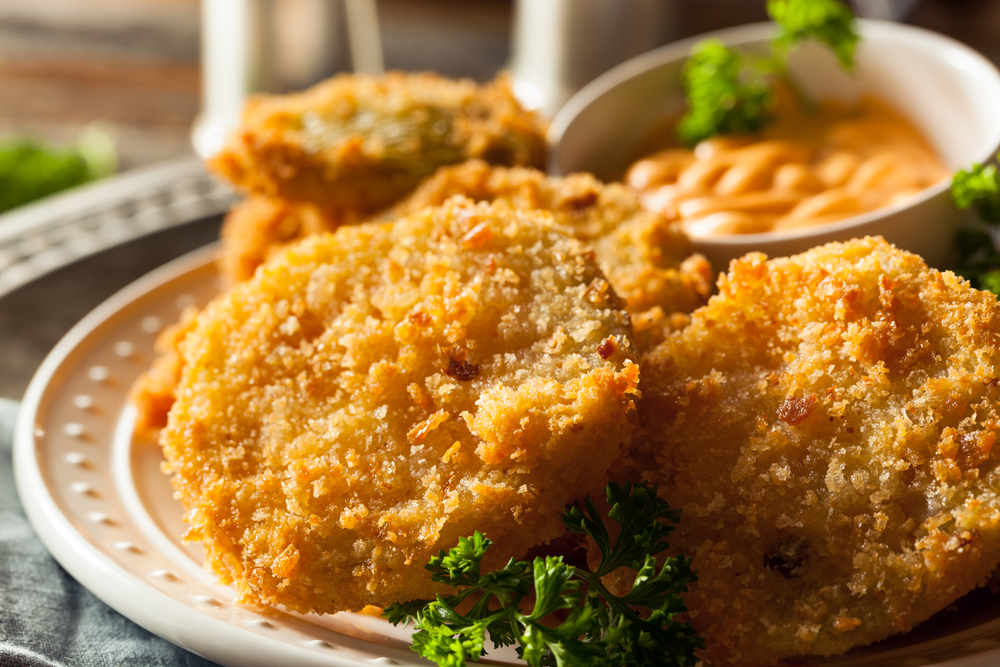 fried green tomatoes with a dipping sauce on a plate with greens for garnish from one of the best restaurants in ocean city longboard cafe